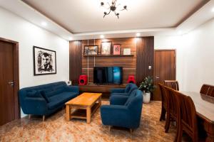 un soggiorno con sedie blu, tavolo e TV di AK Homestay - Motorbike Rental - Cao Bang City a Cao Bằng