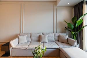 a living room with a couch and a plant at Brassbell l Nile view serviced apartments in zamalek in Cairo
