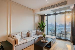 a living room with a couch and a large window at Brassbell l Nile view serviced apartments in zamalek in Cairo