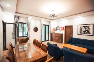 un soggiorno con tavolo in vetro e divano blu di AK Homestay - Motorbike Rental - Cao Bang City a Cao Bằng