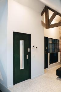 uma porta verde no meio de uma sala de estar em Gezellige loft met twee slaapkamers em Ieper