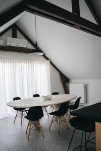 Gezellige loft met twee slaapkamers في إبير: غرفة طعام مع طاولة بيضاء وكراسي