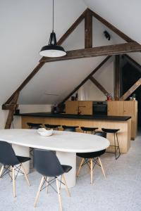 a dining room with a white table and chairs at Gezellige loft met twee slaapkamers in Ypres