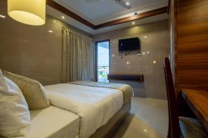 um quarto de hotel com uma cama e uma janela em HOTEL SIVAS em Perambalūr