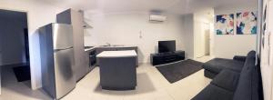 eine Küche und ein Wohnzimmer mit einem Sofa und einem Kühlschrank in der Unterkunft Hedland Hotel in Port Hedland