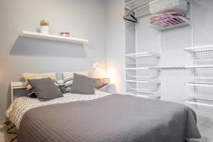 a bedroom with a bed with white shelves at Apartament Nad Stawem in Gdańsk