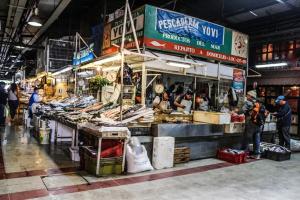 a market with people standing in front of a fish market at AH Teatinos in Santiago