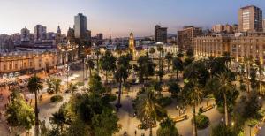 een stad met een plein met palmbomen en gebouwen bij AH Teatinos in Santiago