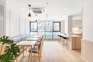 a cafeteria with tables and chairs and a kitchen at LiveZen Bangkok Sukhumvit in Khlong Toei