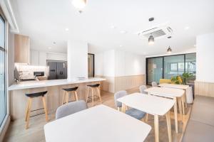 a cafeteria with tables and chairs and a kitchen at LiveZen Bangkok Sukhumvit in Khlong Toei