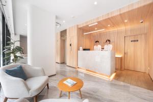 two women standing at a counter in a lobby at LiveZen Bangkok Sukhumvit in Khlong Toei