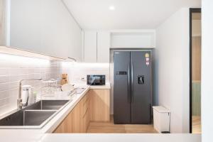 a kitchen with a refrigerator and a sink at LiveZen Bangkok Sukhumvit in Khlong Toei