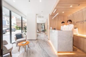 two people standing at a counter in an office at LiveZen Bangkok Sukhumvit in Khlong Toei