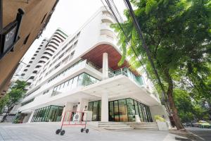 a white building with a sign in front of it at LiveZen Bangkok in Khlong Toei