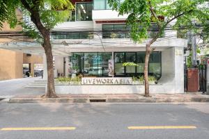 a building with a sign on the side of a street at LiveZen Bangkok Sukhumvit in Khlong Toei