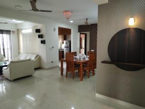 een woonkamer en eetkamer met een tafel en stoelen bij Luxury 3BhK Service Apartment Manyata tech Park Hebbal in Bangalore