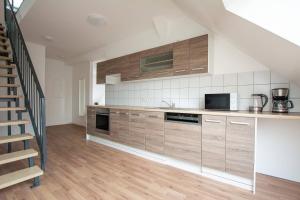eine Küche mit Holzschränken und einer Treppe in der Unterkunft T&K Apartments - DUISBURG - Frisch renovierte 4 Zimmer Maisonetten mit Privatparkplätzen in Duisburg