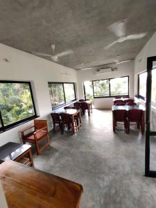 a dining room with tables and chairs and windows at Paradise Le Tamarin in Auroville