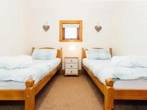 2 camas individuales en una habitación con espejo en Middle Byre, en Castle Douglas
