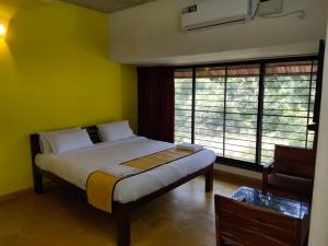 a bedroom with a bed in a room with yellow walls at Paradise Le Tamarin in Auroville