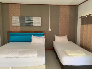 - 2 lits dans une petite chambre avec des oreillers blancs dans l'établissement บุญพน รีสอร์ต Maldives resort&restaurant, à Wichian Buri