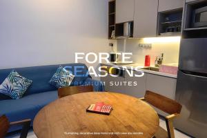 a living room with a table and a blue couch at Forte Seasons Genting Geo38 in Genting Highlands