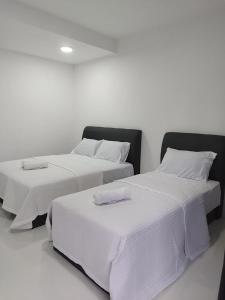 twee bedden naast elkaar in een kamer bij Afeeya The Roomstay in Kuala Terengganu