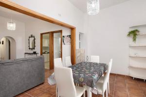 ein Esszimmer mit einem Tisch und weißen Stühlen in der Unterkunft Casa del Mar en Tacoronte in Tacoronte