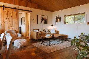 ein Wohnzimmer mit einem Sofa und einem Tisch in der Unterkunft Kootenay Lakeview Retreats - Forest Cabin in Nakusp