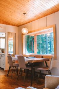 una sala da pranzo con tavolo, sedie e finestra di Kootenay Lakeview Retreats - Forest Cabin a Nakusp