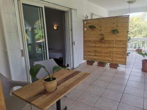 a dining room with a wooden table and a potted plant at Artists house in Rivière Noire