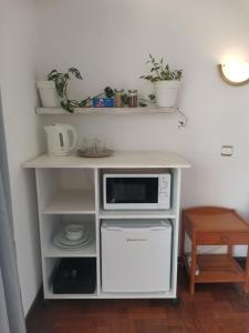 a white counter with a microwave on top of it at Artists house in Rivière Noire