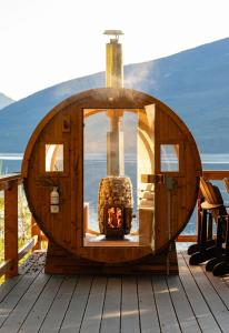 a wooden circle with a fireplace on a deck at Kootenay Lakeview Retreats - Forest Cabin in Nakusp