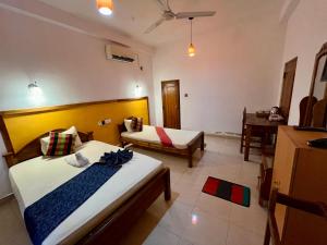 ein Hotelzimmer mit 2 Betten und einem Tisch in der Unterkunft Hotel Green View Buttala in Buttala