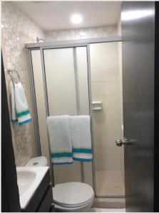 a bathroom with a toilet and a shower with towels at Casa Edith in Cartagena de Indias