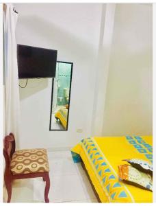 1 dormitorio con cama, espejo y silla en Casa Edith en Cartagena de Indias