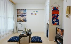 a living room with a table and a tv at KIYAZA City Sapporo CALIDO in Sapporo