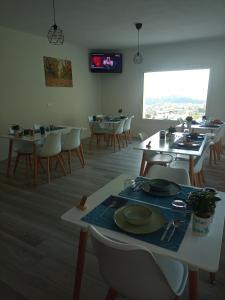 uma sala de jantar com mesas e cadeiras e uma televisão em Casa Vittoria Guest House em Romano D'Ezzelino