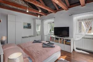een witte slaapkamer met een bed en een televisie bij Holiday Home Meja Private Pool- Happy Rentals in Križišće