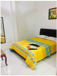 Cama en habitación con manta amarilla en Casa Edith, en Cartagena de Indias