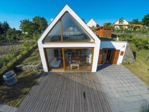 una pequeña casa con una gran ventana en una terraza en Ég & Föld Borvendégház, en Szekszárd