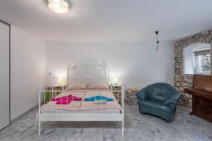 een slaapkamer met een bed en een stoel bij Holiday Home Meja Private Pool- Happy Rentals in Križišće