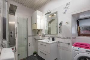 een badkamer met een wastafel en een wasmachine bij Holiday Home Meja Private Pool- Happy Rentals in Križišće