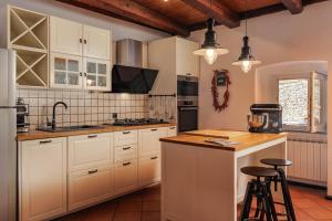 een keuken met witte kasten en een aanrecht met krukken bij Holiday Home Meja Private Pool- Happy Rentals in Križišće