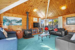 ein Wohnzimmer mit einem Kamin in einer Hütte in der Unterkunft Five Mile Yay - Five Mile Bay Holiday Home in Taupo
