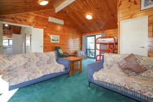 ein Wohnzimmer mit 2 Sofas und einem Tisch in der Unterkunft Five Mile Yay - Five Mile Bay Holiday Home in Taupo
