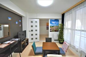 a living room with a table and chairs and a desk at KIYAZA City Sapporo CALIDO in Sapporo