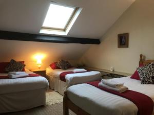 a attic room with two beds and a window at The Victoria Hotel in Pwllheli