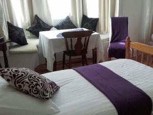 a bedroom with a bed and a table and chairs at The Victoria Hotel in Pwllheli