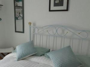 Una cama blanca con dos almohadas encima. en The Victoria Hotel, en Pwllheli